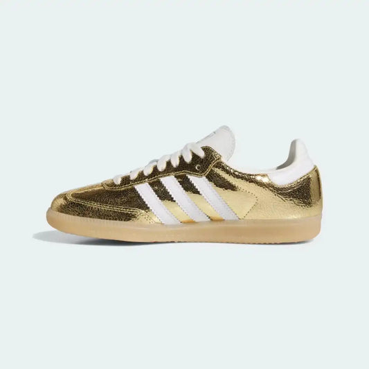 Gold metallic Adidas Samba OG side view showing reflective finish, white leather accents and classic gum outsole styling.